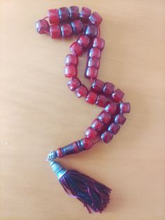 a tasseled beaded necklace is laying on a table with a tassel