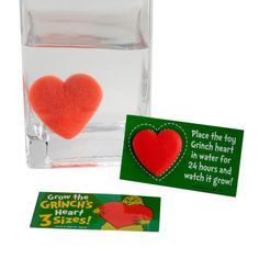 there is a small heart in a glass with two stickers next to the card