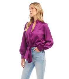 This top is crafted from a silky fabric and features a stand-up collar and tie waistband for an elegant aesthetic. The remarkable Magenta color adds a bold statement to any look, whether you choose to dress it up or down with denim. Final Sale - No returns or exchanges. Color - Magenta. Blouson Sleeve. Tie at waist. Button down. No pockets. Long sleeve. Satin fabrication. Fabric - 53% Polyester. 47% Recycled Polyester. Care- Dry clean. Spring Party Blouse With Tie Waist, Elegant Spring Blouse With Tie Waist, Fall Night Out Blouse With Tie Neck, Fall Tie Neck Top For Night Out, Elegant Belted Blouse For Spring, Fitted Tie Waist Blouse For Party, Elegant Spring Belted Blouse, Spring Satin Tie Neck Blouse, Spring Satin Tie Neck Top