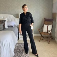 a woman standing next to a bed in a bedroom