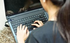 a woman is typing on her laptop computer