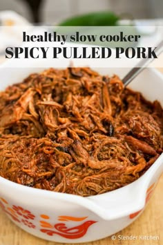 a white bowl filled with pulled pork on top of a wooden table