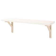 a white bench sitting on top of a wooden table next to a white wall and floor