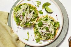 two open faced sandwiches with lettuce and toppings on a plate next to dipping sauce