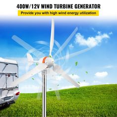 a wind turbine generator in the middle of a green field with a trailer behind it