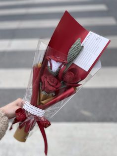 someone is holding a bouquet of flowers on the street