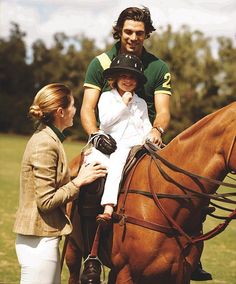 a woman sitting on the back of a brown horse next to a man in a green shirt