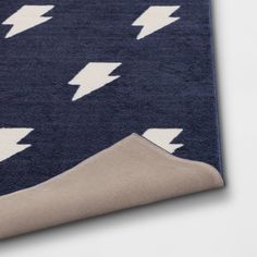 a blue rug with white lightnings on it and a beige area rug in the middle