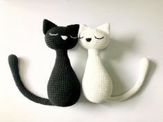 two crocheted black and white cats sitting next to each other