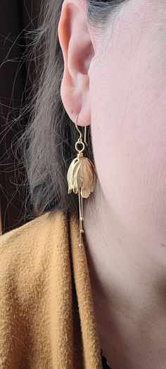 I thought to add a different flower to my store bouquet. Wondering in my favorite bead store, I found these unique gold plated brass tulip flower tops. Boy, was I in love! The free movement of the pollen dangles add an elegant touch. The hooks are hand hammered 14K gold plated over brass. I wear a pair when I go out on a date, to a wedding or even the opera.  Bridesmaids would be delighted to get a pair as a gift. They look great with any color and especially floral patterns. Gold Petal Flower Earrings For Gifts, Gold Flower Earrings With Birth Flower Detail, Delicate Gold Petal Flower Earrings, Gold Birth Flower Drop Earrings, Gold Birth Flower Shaped Earrings, Gold Teardrop Flower Charm Earrings, Gold Teardrop Flower Earrings With Charm, Gold Teardrop Birth Flower Earrings, Gold Dangle Earrings With Birth Flower