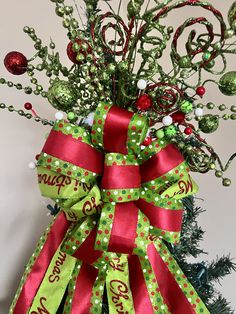 a green and red bow on top of a christmas tree