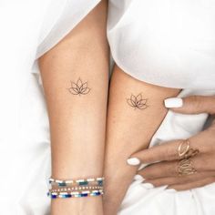 two women with matching tattoos on their legs, both holding each other's hands