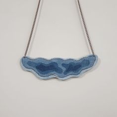 a blue piece of fabric hanging from a chain