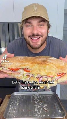 a man holding up a large sandwich in front of his face with the words let's make this virtual dish sandwich