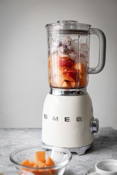 a blender filled with fruit sitting on top of a counter