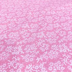 pink and white fabric with small flowers on it