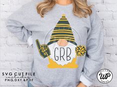 a woman wearing a gray sweatshirt with an image of a gnome on it and the words grb