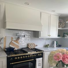 a kitchen with an oven, stove and flowers in vases on the counter top