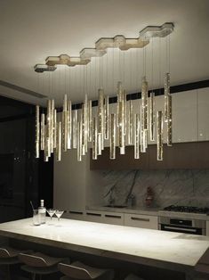 a modern chandelier hanging over a kitchen counter