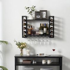 a wine rack with bottles and glasses on it in front of a wall mounted shelf