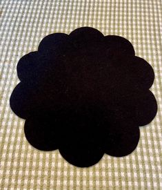 a black flower sitting on top of a white checkered tablecloth covered bed sheet