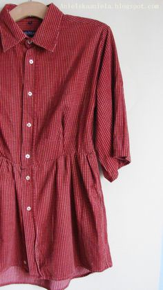 a red and white striped shirt hanging on a wall next to a wooden hanger