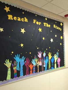 a bulletin board with hand prints on it and stars above the words reach for the star