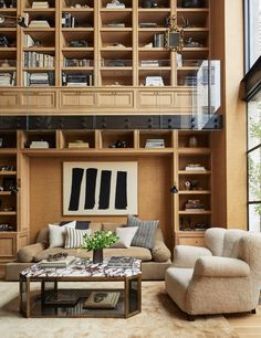 a living room filled with furniture and bookshelves next to a large glass window