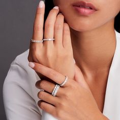 a woman wearing two diamond rings on her finger