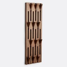 a wooden wall hanging on the side of a wall with three shelves attached to it