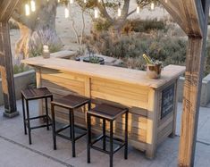 an outdoor bar with three stools under it