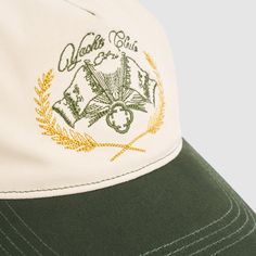 a green and white baseball cap with the words golf club on it's front