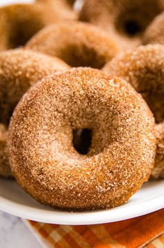 four sugared donuts on a white plate