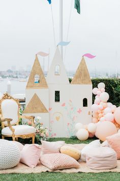 a castle is set up with balloons and other decorations for an outdoor party or baby shower