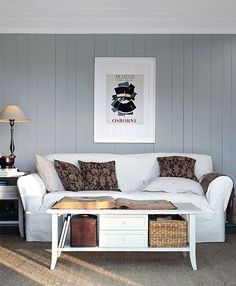 a living room filled with furniture and a painting on the wall above it's coffee table