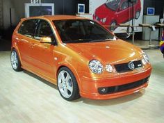 an orange car is parked in a showroom