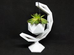 a white sculpture with a plant in it