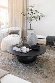 a living room filled with furniture and a vase on top of a table in front of a window