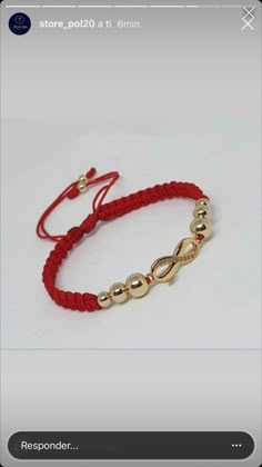 a red string bracelet with two gold beads