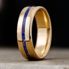 a gold ring with blue stripes on the inside and inlays to make it stand out