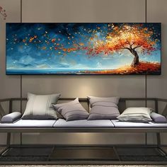 a large painting hanging on the wall above a couch in a living room with pillows