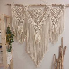 a wall hanging made out of macrame sticks and other items in a room