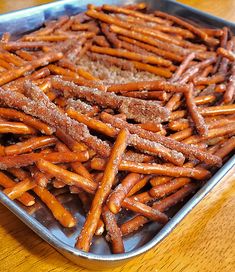 there is a tray full of pretzels sitting on the table with breadcrumbs in it