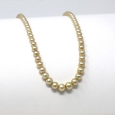 "Pretty vintage circa 1940s era 14k yellow gold simulated pearl necklace! This lovely necklace is comprised of graduated simulated pearl beads in off white, with a 14k yellow gold fish hook clasp. A classic 1940s era fashion accessory, featuring June's birthstone! *Sale - price reduced from $195 USD to $175 USD.  ERA - Circa 1940s - Retro METAL / MATERIAL - 14k yellow gold, simulated pearls MARKINGS / HISTORY - Clasp is marked \"14K A\" CONDITION - Good vintage condition. Yellow gold metal has b Classic Gold Single Strand Pearl Necklace, Classic Gold Pearl Necklace, Classic Gold Pearl Necklace For Formal Occasions, Gold Pearl Necklace For Formal Occasions, Vintage Yellow Gold Single Strand Necklace, Classic Gold Pearl Necklace With Round Beads, Classic Gold Necklace For Formal Occasions, Vintage Single Strand Gold Pearl Necklace, Antique Gold Pearl Necklace For Formal Occasions