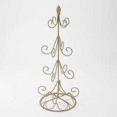 a gold metal stand with two hooks on it's sides and one hook at the top