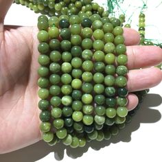 a hand holding a bunch of green beads