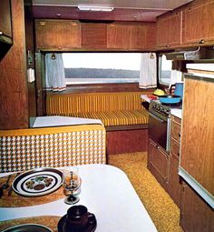 the interior of a camper with wood cabinets and checkered table cloth on it