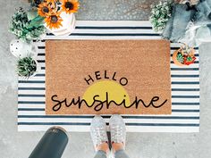 someone standing in front of a door mat that says hello sunshine