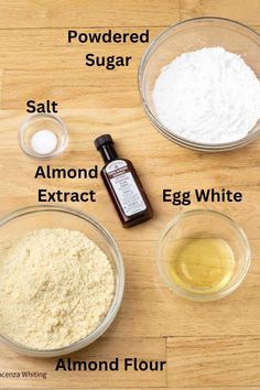 ingredients to make an egg white cake sitting on a wooden counter top, including flour, sugar, salt, and almonds