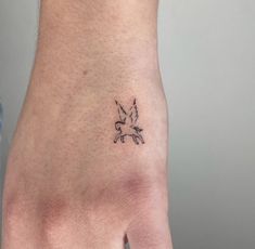 a hand with a small bird tattoo on it